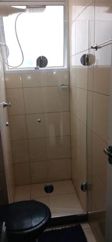 a bathroom with a shower with a toilet and a window at Apartamento porto dos mares in Salvador