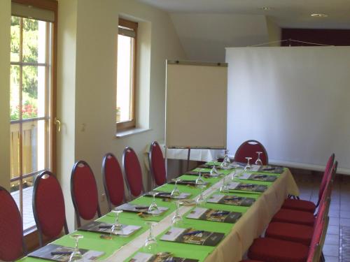 a conference room with a long table with red chairs at Landhotel Dresden in Dresden