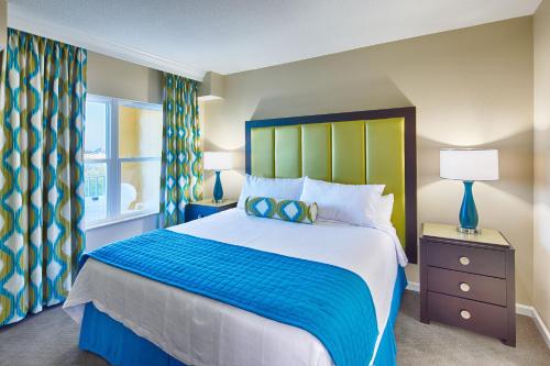 a bedroom with a large bed with a blue and green headboard at Vacation Village at Parkway in Orlando