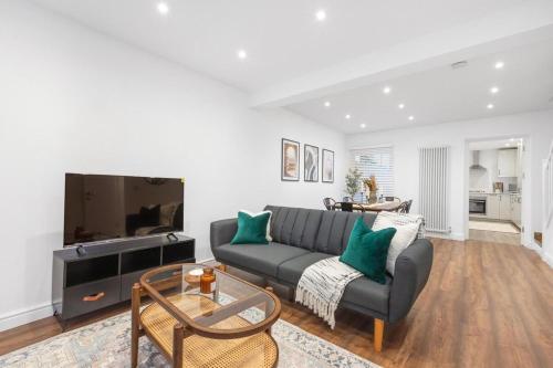 a living room with a couch and a tv at Furnished Terraced House near Public Attractions, 5 min to Public Transport in Hemel Hempstead