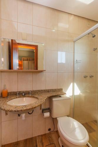 a bathroom with a toilet and a sink and a shower at Hotel Morada Del Este in Canoas
