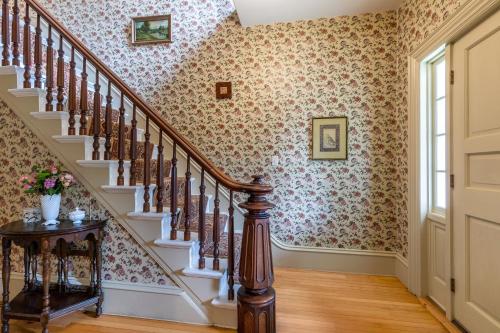 a staircase in a home with floral wallpaper at The School House - Walk to all Shops and Restaurants - New Remodel in Manchester