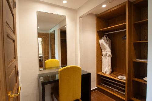 a dressing room with a yellow chair and a mirror at Tikida Golf Palace in Agadir