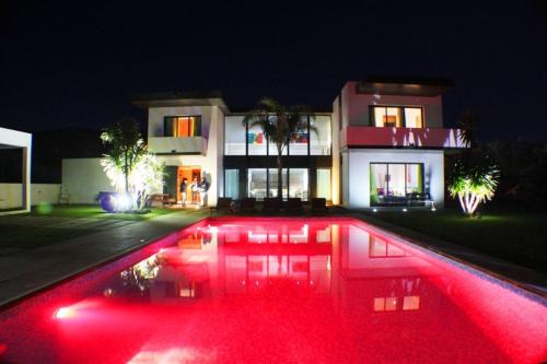 a house with a pool in front of a house at night at Luxury Villas in Vila Franca do Campo