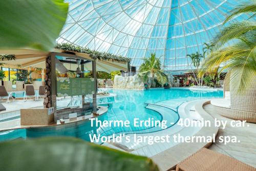 a swimming pool in a building with a glass ceiling at Cosy 4 room apartment - AC - free parking - balcony - workspace in Oberschleißheim