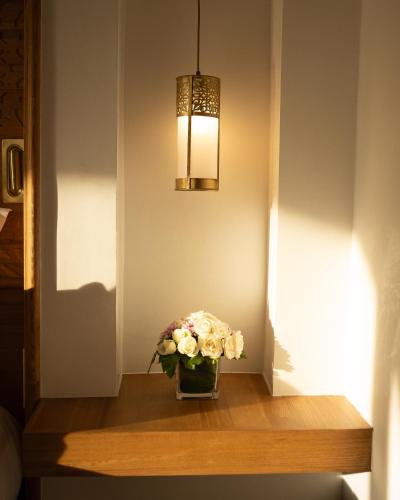 a vase of flowers on a table with a light at Tikida Golf Palace in Agadir