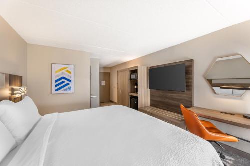 a hotel room with a bed and a flat screen tv at Holiday Inn Express Crestwood by IHG in Crestwood