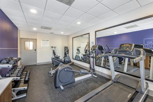 a fitness room with treadmills and elliptical machines at Holiday Inn Express Crestwood by IHG in Crestwood