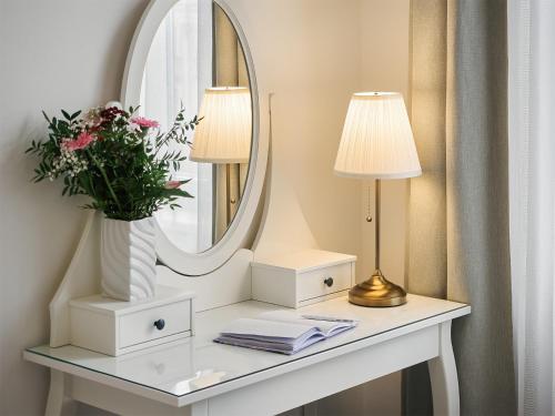 a dressing table with two lamps and a mirror at IMPERIAL Apartments in Karlovy Vary