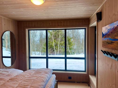 1 dormitorio con ventana grande y cama en Immaculate Cabin in the Heart of Beitostølen, en Beitostølen
