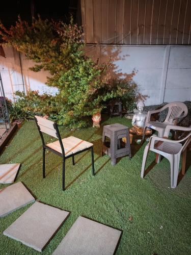 a yard with two chairs and a table and a stool at Descanso Sureño Hospedaje in Valdivia