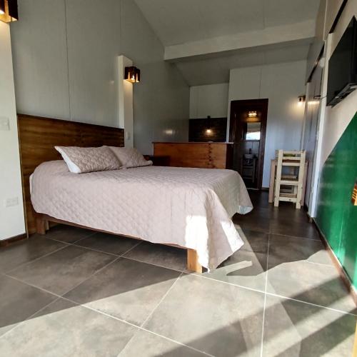 a bedroom with a bed and a table and chairs at Flores del Limay cabañas in Dina Huapi