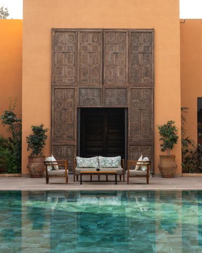 a pool in front of a building with a couch in front at Tikida Golf Palace in Agadir