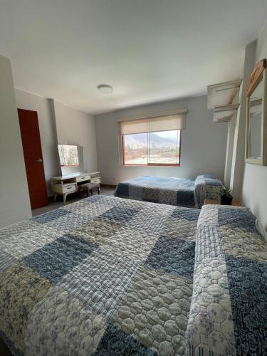 a bedroom with two beds and a window at Casa Huertos CIENEGUILLA in Cieneguilla