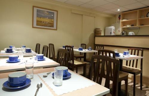 ein Zimmer mit Tischen und Stühlen mit blauen Gerichten darauf in der Unterkunft Hôtel Neptune Place d'Italie in Paris