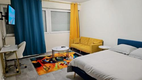 une chambre avec un lit, une chaise et une télévision dans l'établissement Cozy studio 3 min walk to train station, à Metz