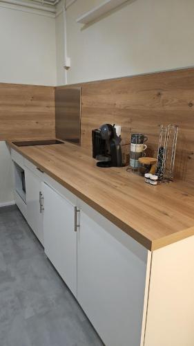 une cuisine avec un comptoir en bois dans une pièce dans l'établissement Cozy studio 3 min walk to train station, à Metz