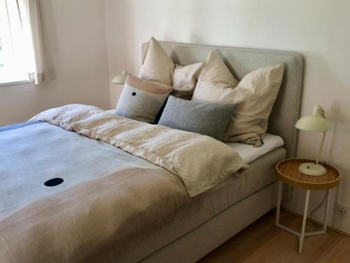 a bed with many pillows on top of it at Zuhaus Freiweidach - Design Holiday Home Chiemgau in Aschau im Chiemgau