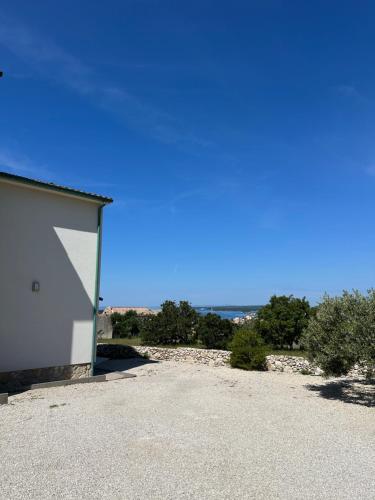 a white building with the ocean in the background at Villa Karmen in Barbat na Rabu