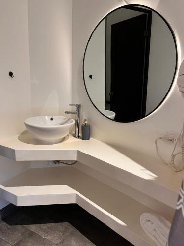 a white bathroom with a sink and a mirror at Grupo Hotelero Colibri in Panajachel