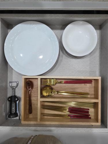 a kitchen sink with two plates and a bowl and utensils at Wonju Aunt Home in Wonju