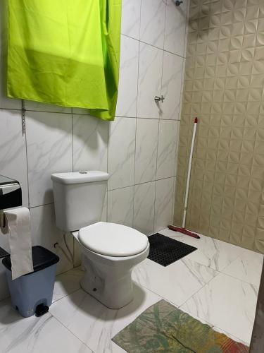a bathroom with a toilet and a green towel at Sítio Oásis in Esmeraldas