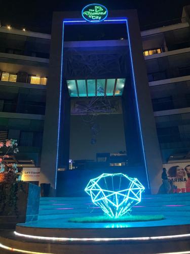 a basketball hoop with a blue light in front of a building at The City Landing Apartments At The Diamond in City in Accra