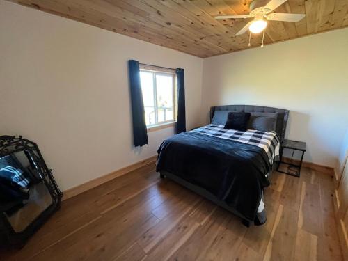 una camera da letto con un letto e un ventilatore a soffitto di Stonebrook Hollow Cabin a Tidwell