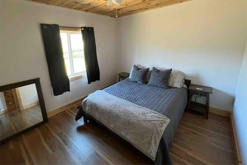 una camera da letto con un letto con cuscini e una finestra di Stonebrook Hollow Cabin a Tidwell