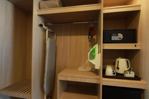a closet with wooden shelves and a appliance in it at Casa Andina Select Tacna in Tacna