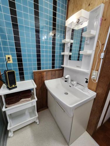 a bathroom with a white sink and a mirror at Fun stay大島 の1棟貸し宿 in Suo Oshima