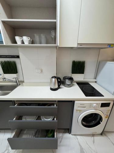 a small kitchen with a stove and a dishwasher at Modern Condo with Pool near Casinos in Clark in Tibo