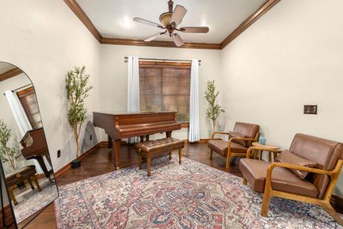 a living room with a piano and a chair at Whispering Brook in Springdale
