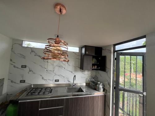 a kitchen with a sink and a pendant light at Cabaña ACALU in Villeta