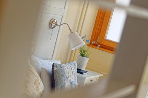 a lamp on a side table next to a bed at Tündérkert Hotel Noszvaj in Noszvaj