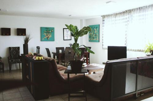 a living room with a television and a dining room at Cómodo y Céntrico Departamento familiar in Oaxaca City