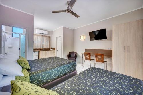a hotel room with two beds and a table at City Oasis Inn Townsville, SureStay Collection by BW in Townsville