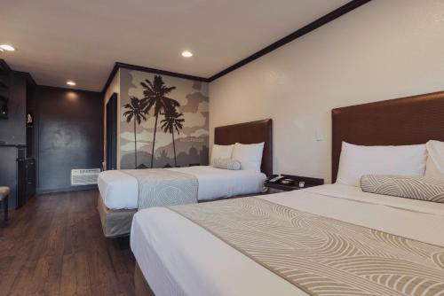 a hotel room with two beds and a painting on the wall at The Dixie Hollywood in Los Angeles