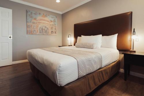 a bedroom with a large bed with a wooden headboard at The Dixie Hollywood in Los Angeles