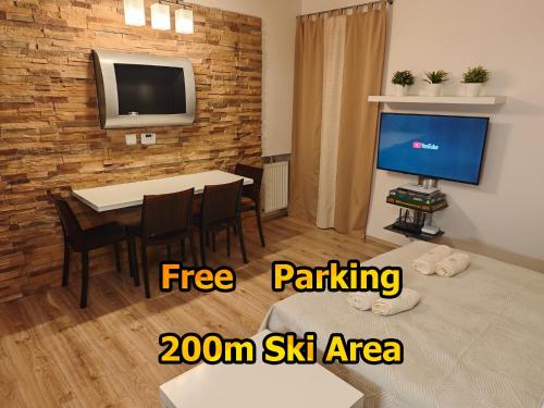 a room with a table and a tv and a dining room at Apartmán SOVA - Klínovec in Loučná pod Klínovcem