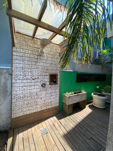 a patio with a bench on a wooden deck at Confortável ampla e com infraestrutura in Capão da Canoa