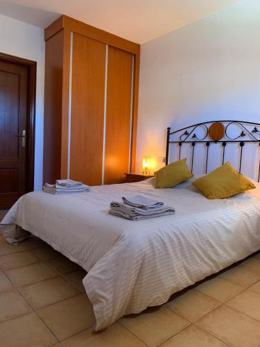 a bedroom with a large bed with towels on it at Villa Bejeque & Barbecue in La Oliva