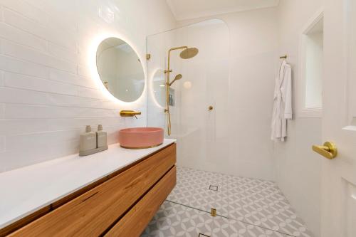 a bathroom with a sink and a mirror at Adelaide Hills Luxury Cottage - The Gladys in Carey Gully