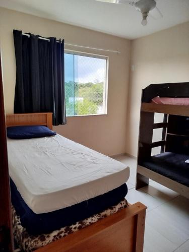 a bedroom with two bunk beds and a window at AP 3 quartos à 10 min de Cabo Frio, Praia do Forte in São Pedro da Aldeia