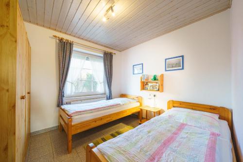 a bedroom with two beds and a window at Am Priel 20 EG in Otterndorf