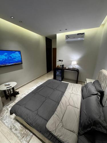 a bedroom with a bed and a tv on the wall at استديو ديار in Al Khobar