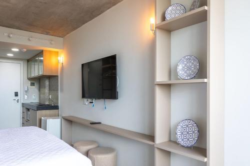 a bedroom with a tv on a wall with shelves at Setai Yacht by DayByDay in João Pessoa