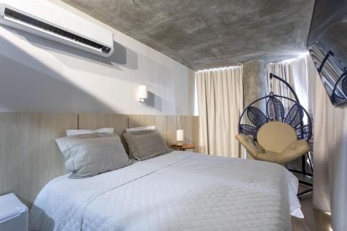 a bedroom with a white bed and a chair at Setai Yacht by DayByDay in João Pessoa