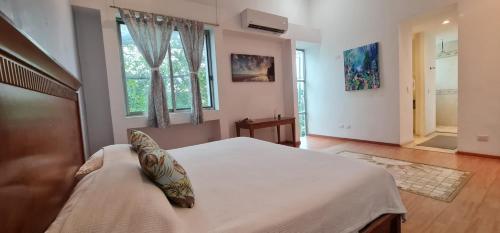 a bedroom with a large bed and a window at Casa La Ceiba in Cancún