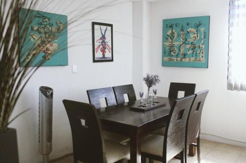 a dining room with a wooden table and chairs at Cómodo y Céntrico Departamento familiar in Oaxaca City